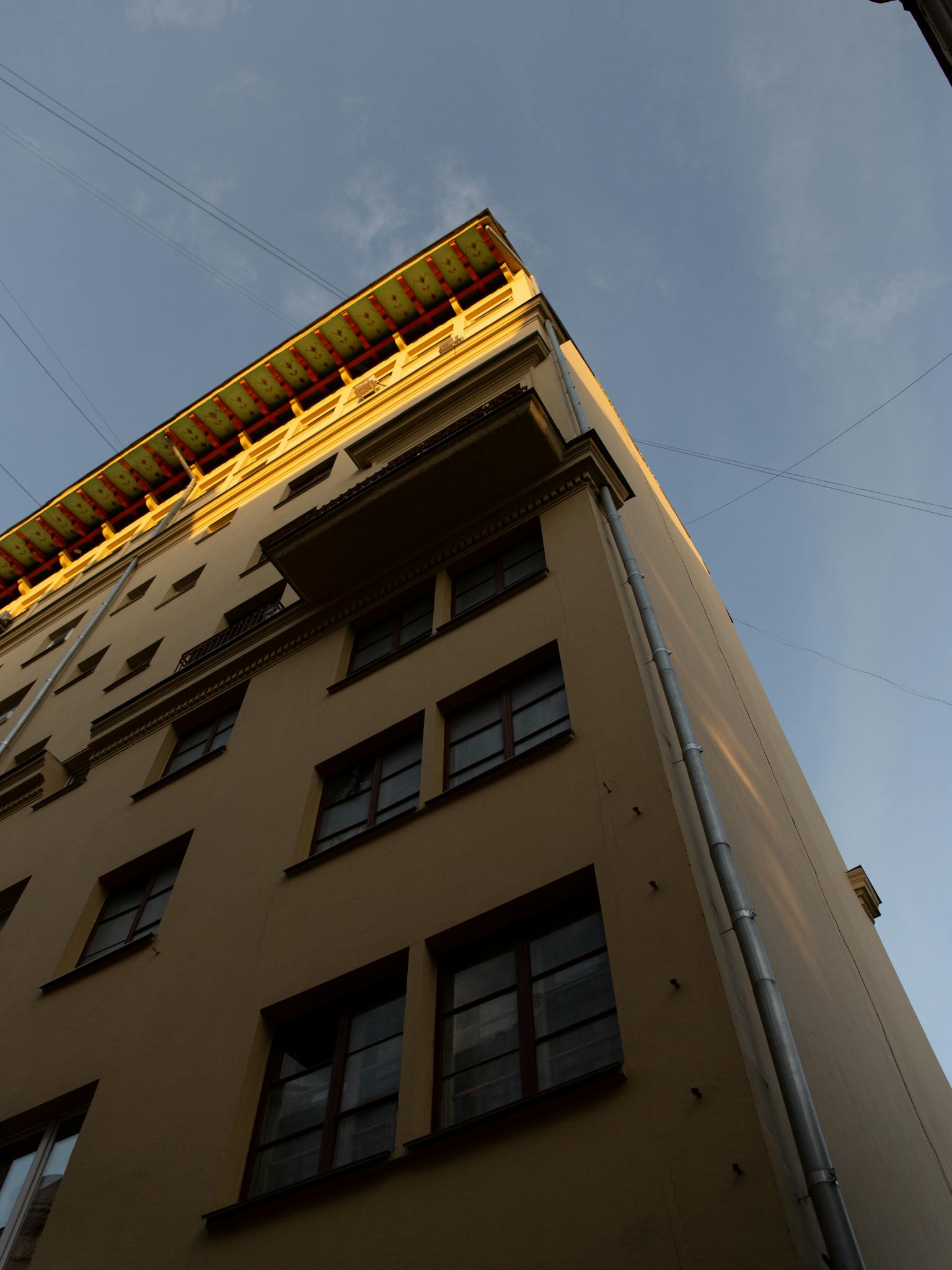 A low angle shot of a multi-story building exterior under a clear blue sky.