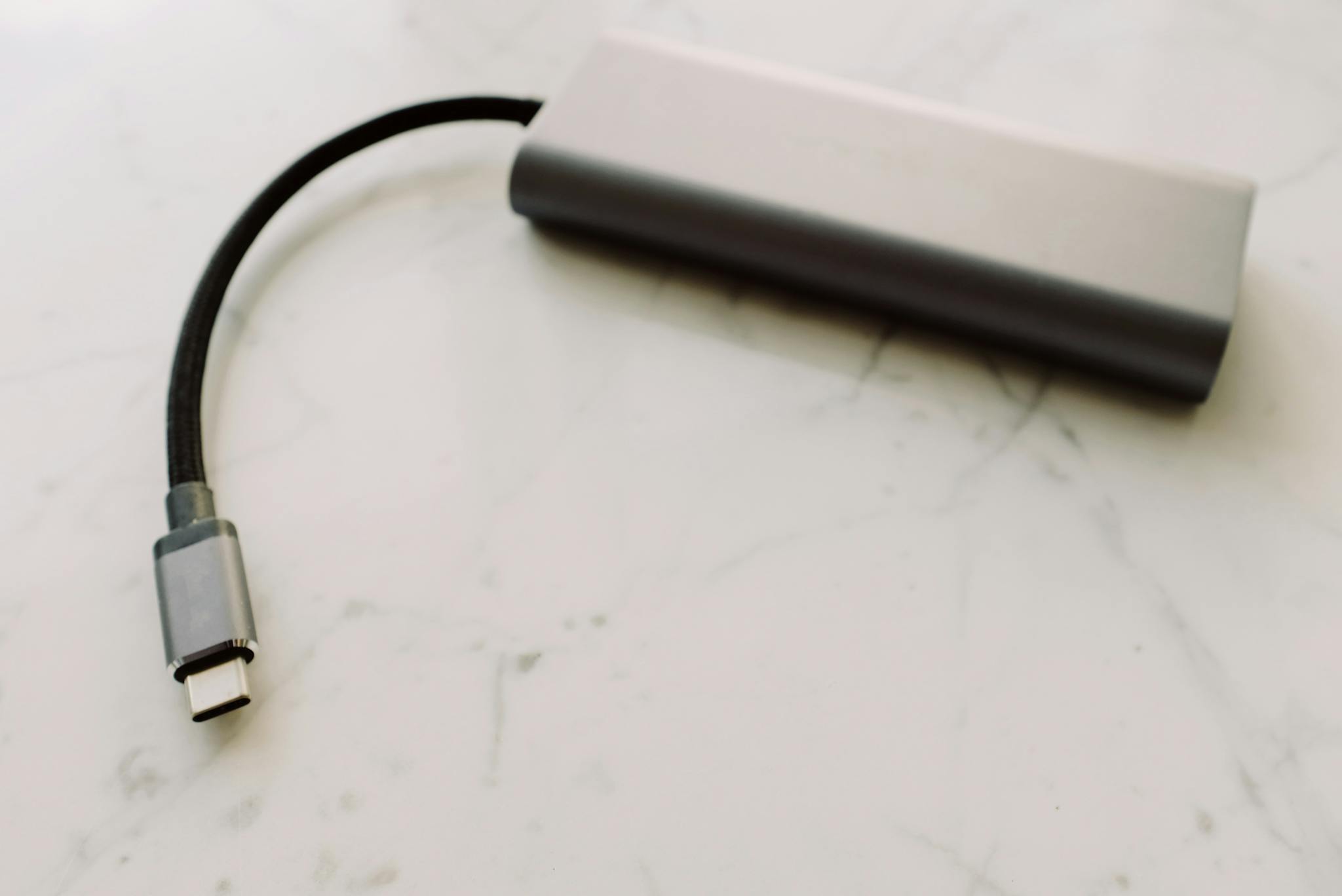 Close-up of a USB-C adapter on a marble surface, showcasing modern technology.